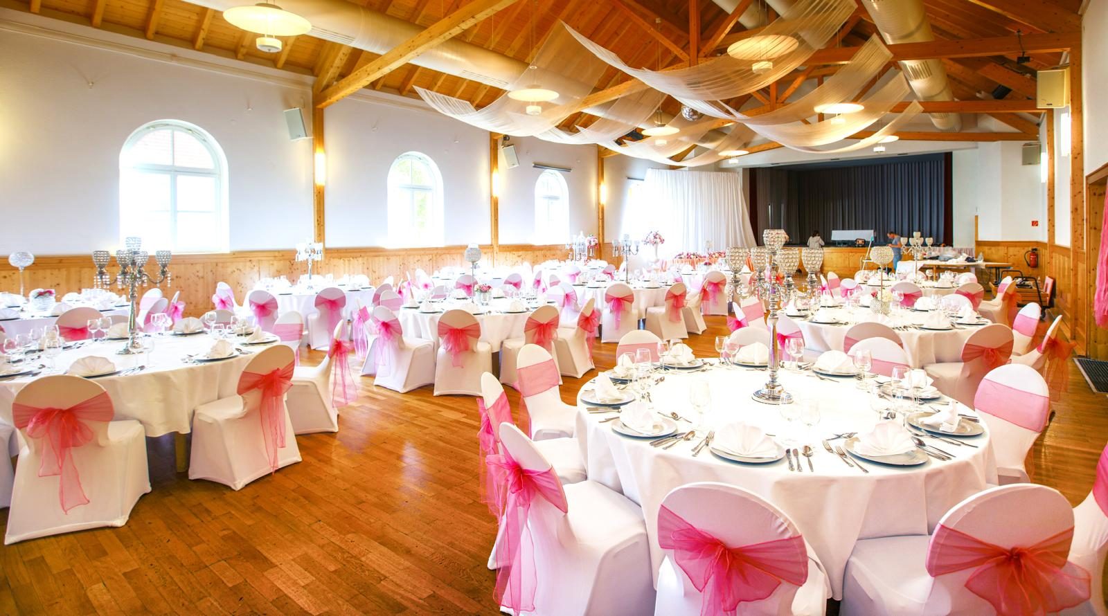 Hochzeitsdekoration in Weiß und Pink mit Kerzenleuchtern im Saal der Festhalle